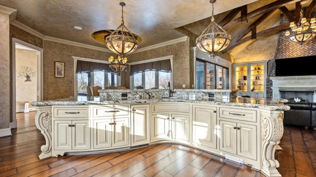 Ornate kitchen island with granite countertops and elegant pendant lights.