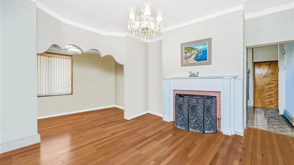 Elegant living room with hardwood floors, a decorative fireplace, and a crystal chandelier.