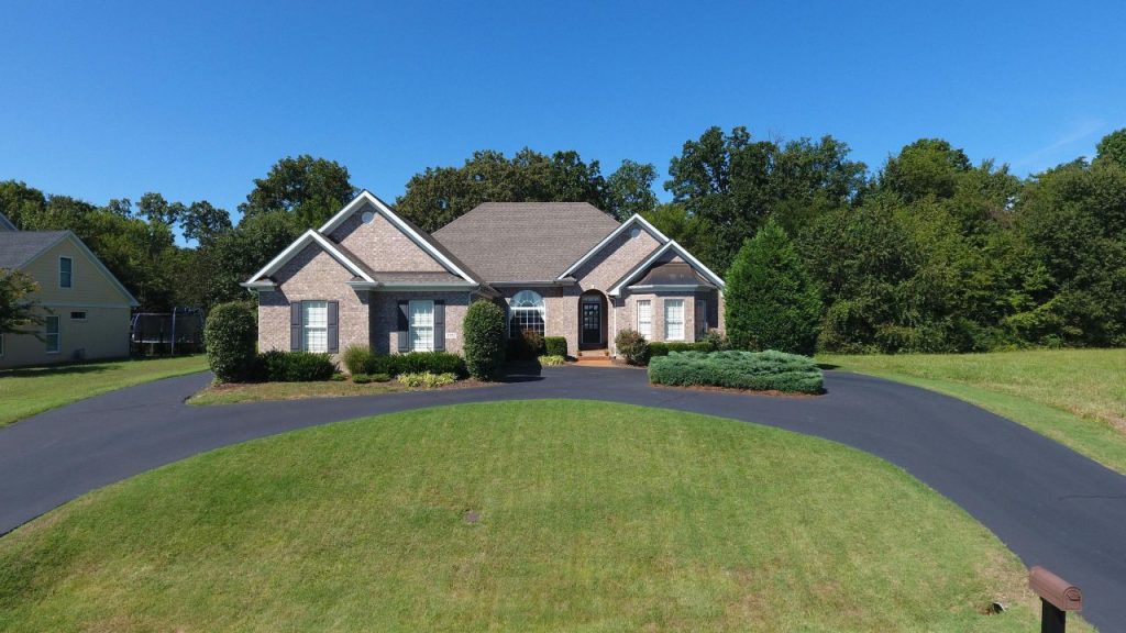 Ranch-style home with a large open space in front of it.