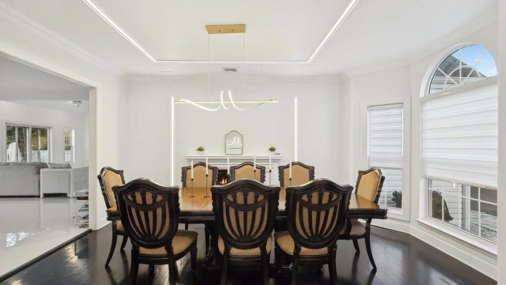 Elegant dining room with classic wood furniture, modern lighting, and a cozy fireplace.