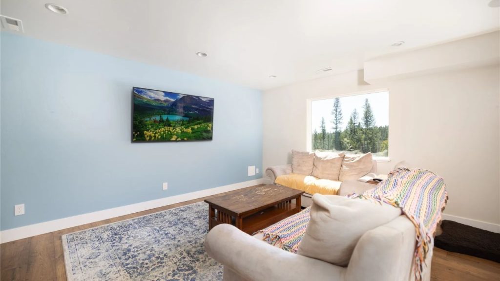 Cozy lounge with a pastel blue wall, large window view, and a comfortable sofa.