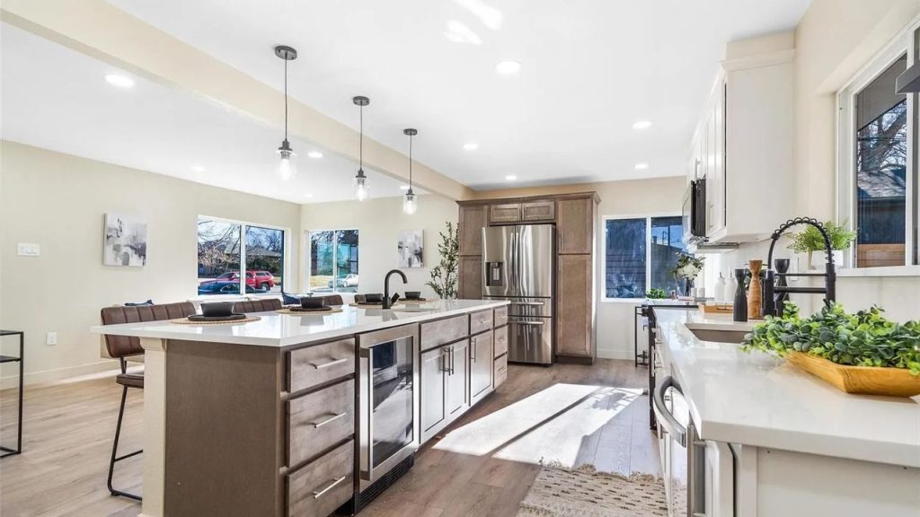 Bright kitchen with a large island, pendant lights, and stainless steel appliances.