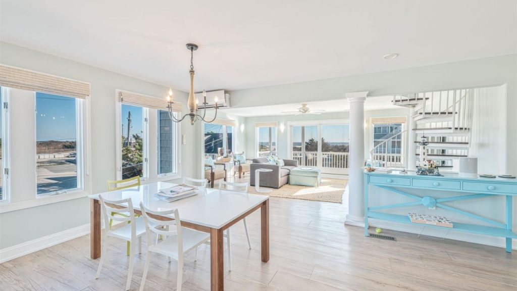 A bright dining area with ocean views, a white table, and a coastal-inspired interior.