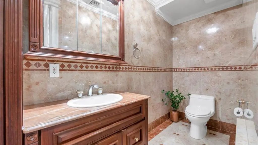 Elegant marble bathroom with a wooden vanity and decorative tiles.