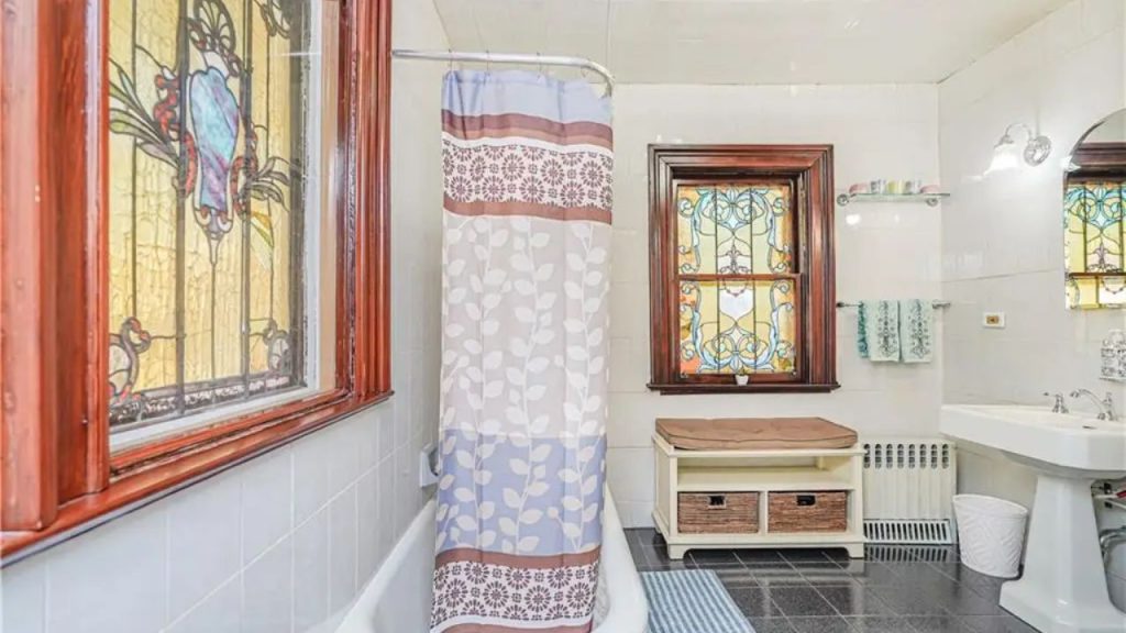 Vintage bathroom with stained glass windows and cozy details.