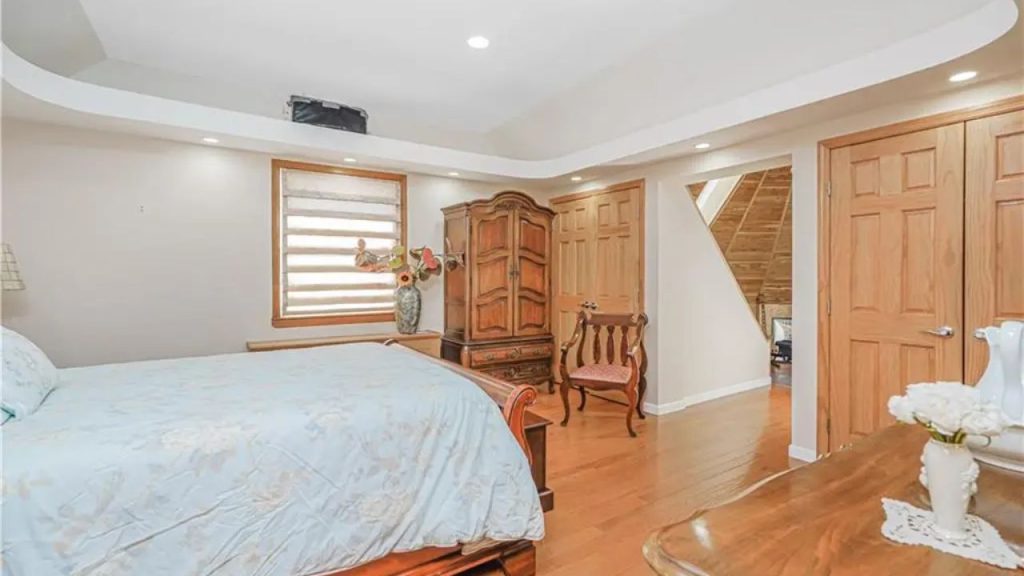 Spacious bedroom with wooden furniture and soft lighting.