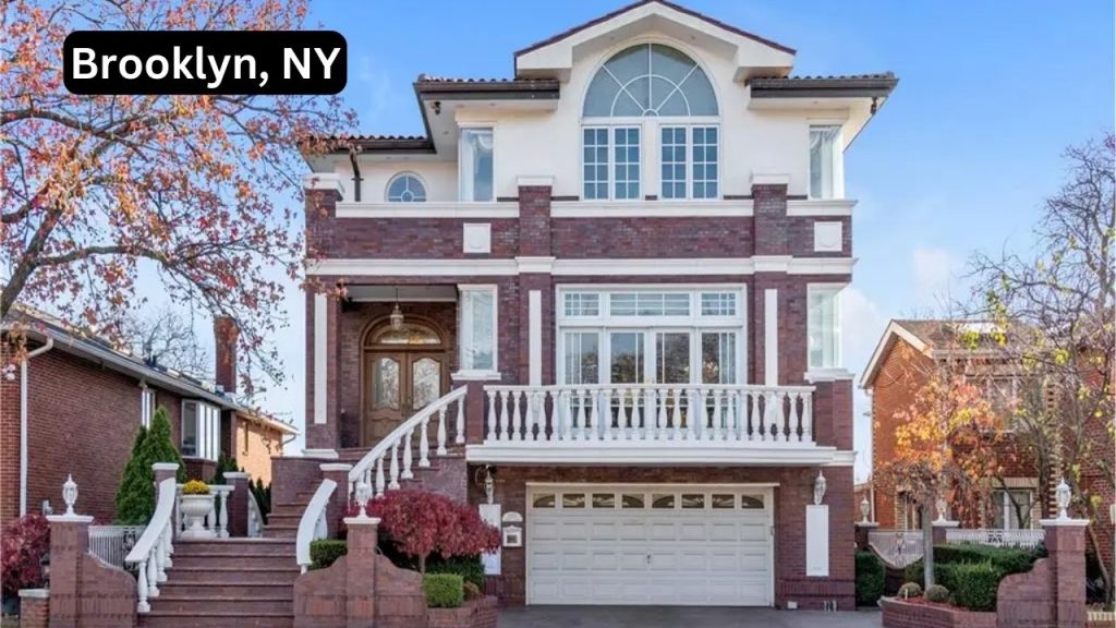 Elegant three-story brick home in Brooklyn, NY, with arched windows, a grand staircase, and a balcony.