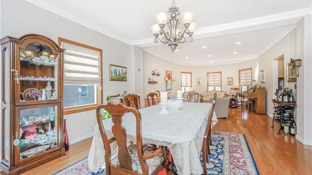 Spacious dining room with a wooden table, china cabinet, and a connected living area.