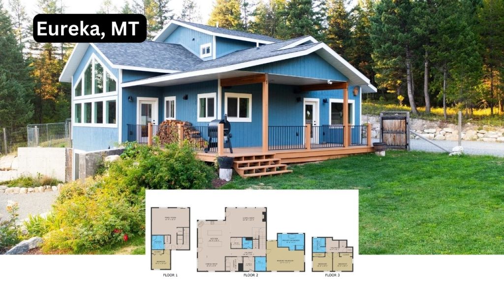 A blue mountain home with large windows, a covered porch, and lush greenery in Eureka, Montana.