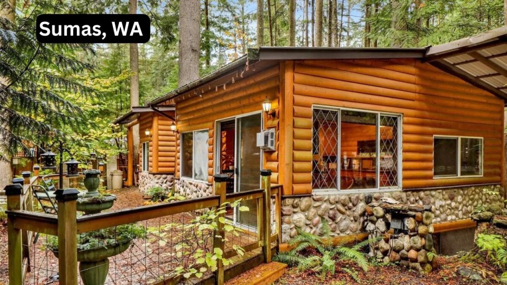 Charming log cabin in Sumas, WA, surrounded by lush forest with warm lighting and rustic details.