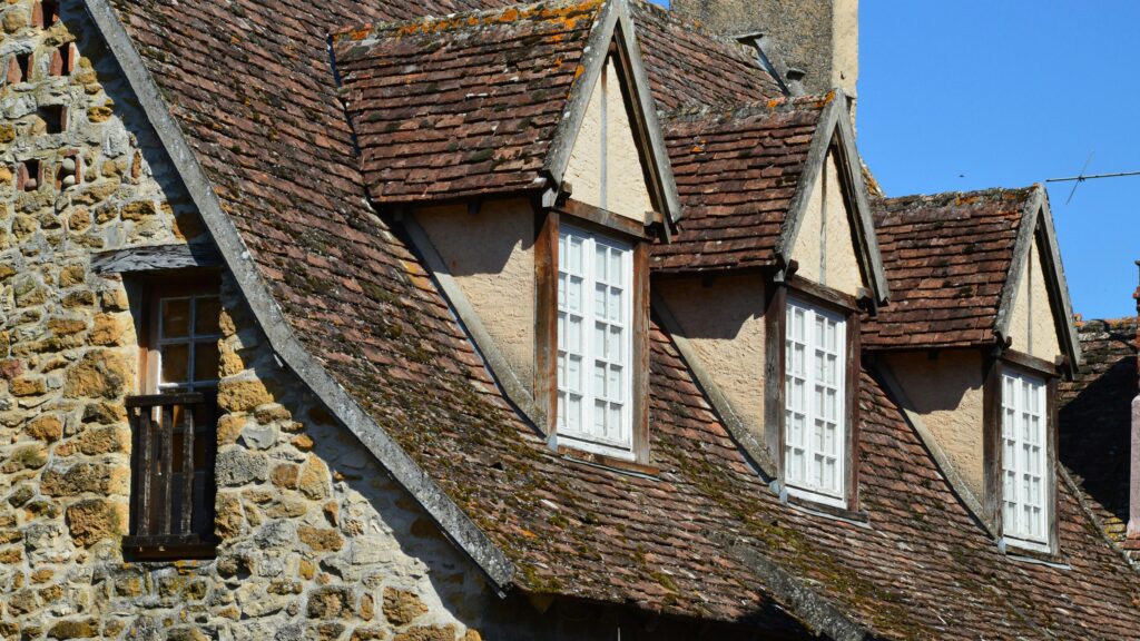 Dormer windows in a roof with shingles.