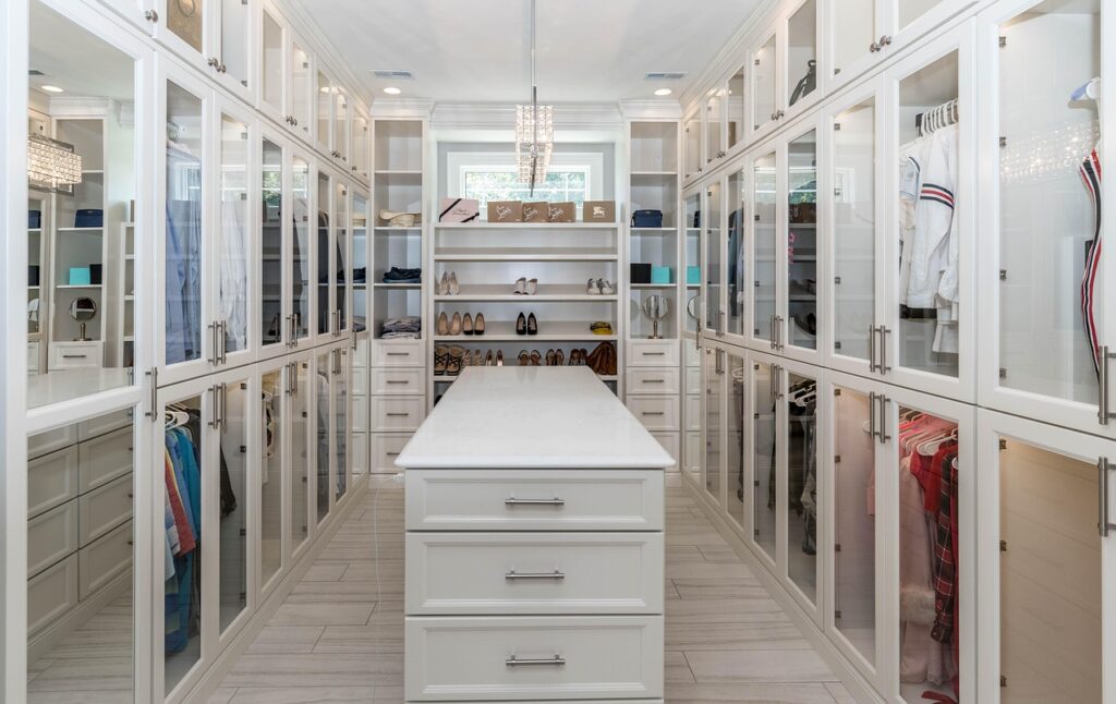 A white walk-in closet filled with clothes and accessories.