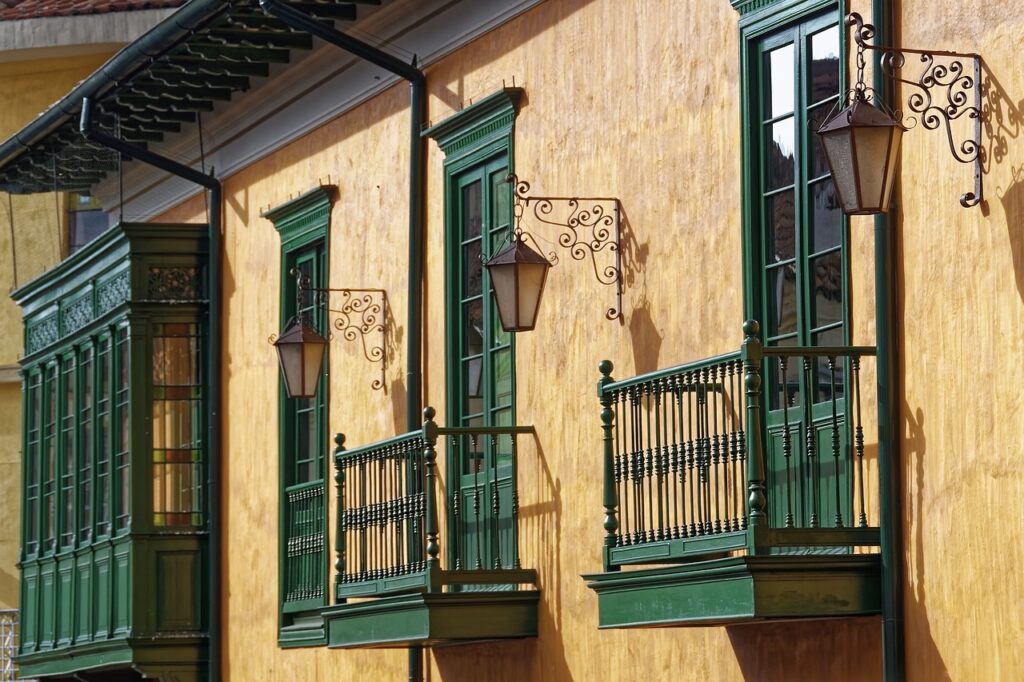 A wall with green doors and wrought iron details.