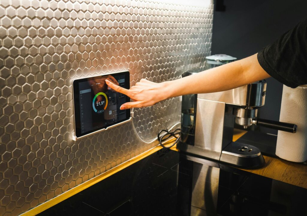 A hand tapping a home automation system on a wall.