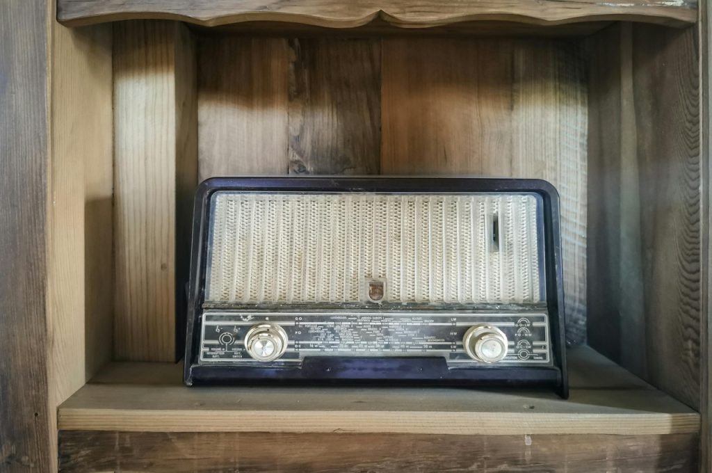 Charm of an Old Radio Resting on rustic wooden shelves, this vintage radio is more than just a decorative piece—it’s a portal to the past. Its worn dials and woven speaker fabric whisper stories of decades gone by, when voices and melodies filled homes with warmth. Whether it once broadcasted evening news, golden-era music, or heartfelt conversations, it remains a nostalgic centerpiece. In a cottage home, this old radio brings a sense of history, echoing the beauty of slow living and treasured memories that never fade.
