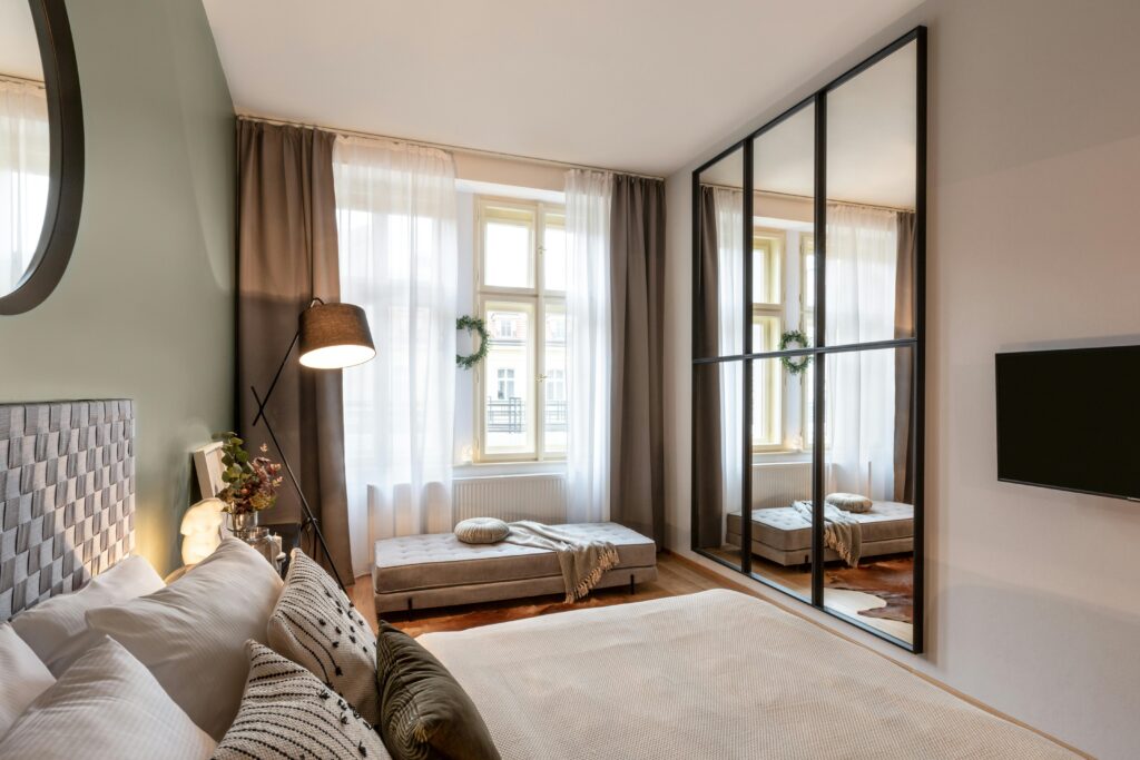 A bedroom with a large mirror.