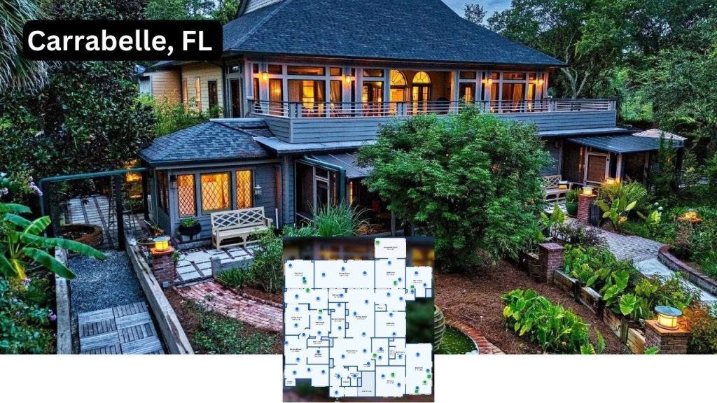 Elegant two-story coastal home in Carrabelle, FL, surrounded by tropical landscaping with soft exterior lighting and a cozy ambiance.