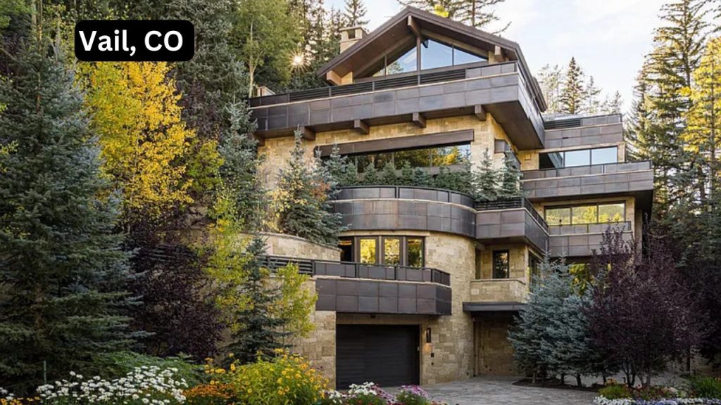 A luxurious multi-family home surrounded by trees and flowers in Vail, CO, with stone and metal design.