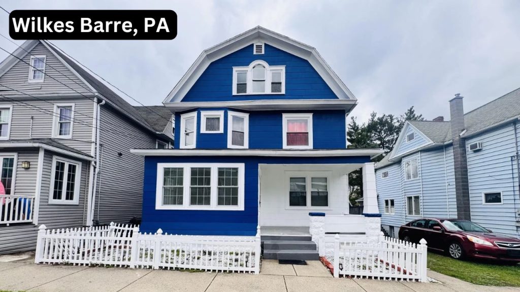 Blue and white multi-family home with colonial features and a white picket fence in Wilkes Barre, PA.