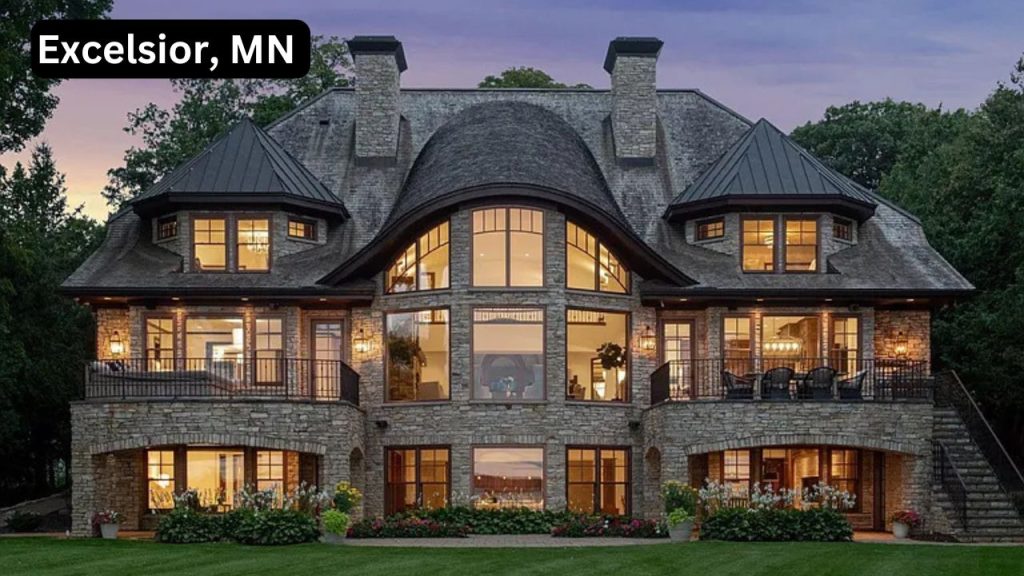 Grand stone manor-style home in Excelsior, MN with elegant lighting and curved architecture.