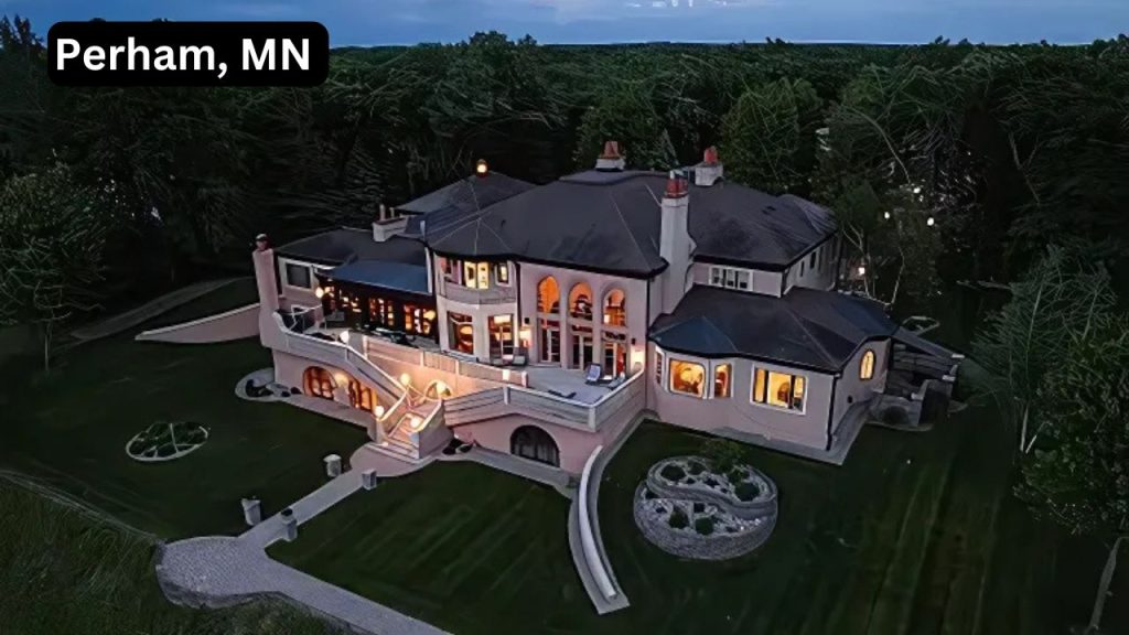 A grand mansion illuminated at dusk, surrounded by dense woods.