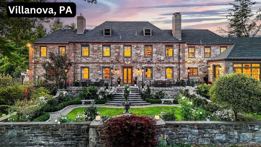 Elegant stone estate in Villanova, surrounded by lush gardens and warm lighting.