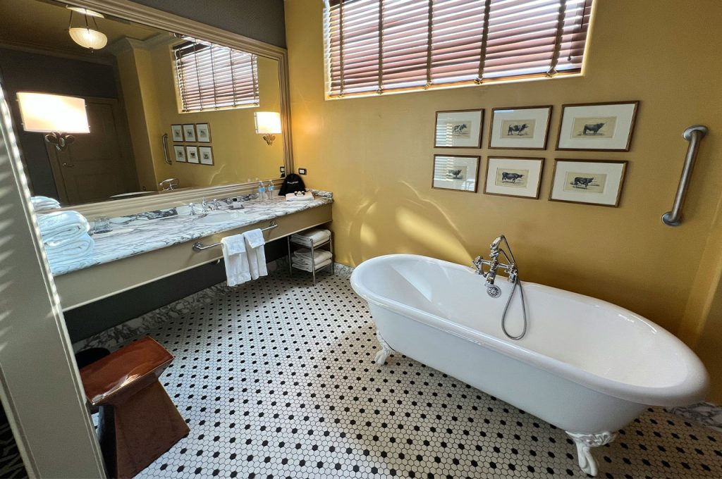 a bathroom with a bathtub, sink, and mirror
