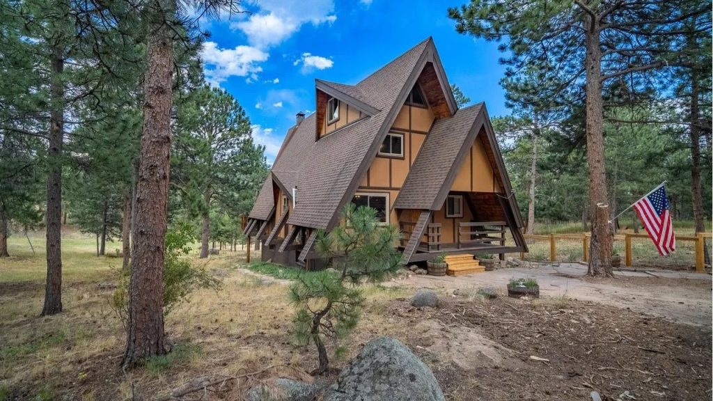 A frame home with steep rooflines nestled in a forested lot in Boulder.