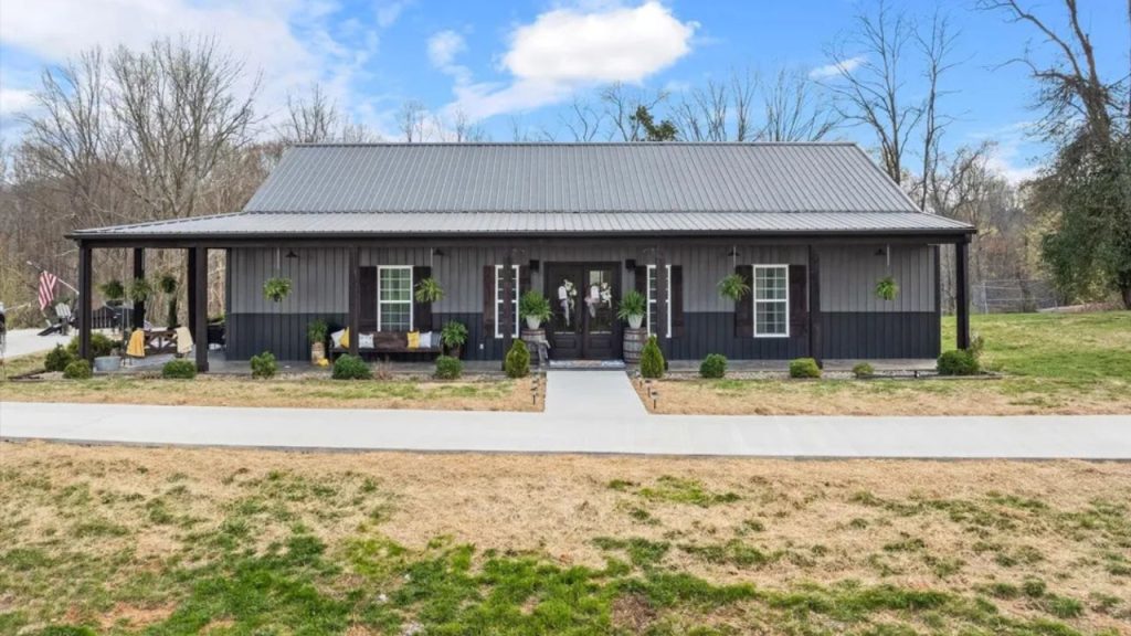 Stylish black barndominium with a spacious front porch, rustic accents, and scenic surroundings in Byrdstown, TN.