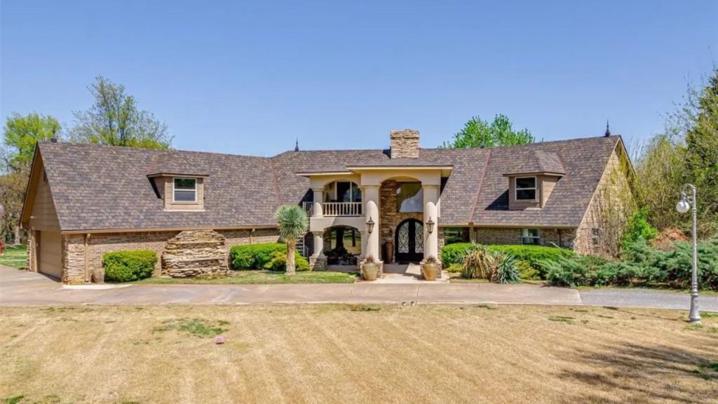 Grand rustic house with gabled roof and stone-accented entryway.