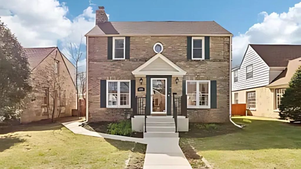 A charming brick home with a modern porch and circular window, nestled among green lawns and neighboring houses.
