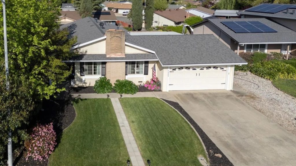 Aerial view of a single-family home with green lawn and neat driveway in Yuba City