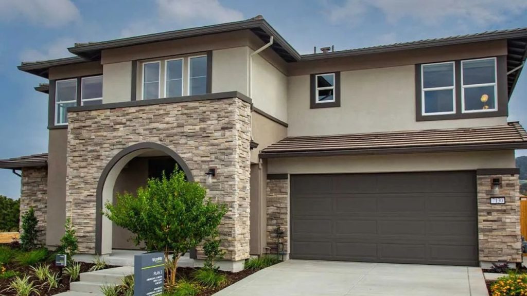 Modern home with arched stone entry and clean stucco finish.