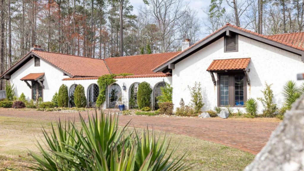 Spanish-style home with arched entryways, terracotta roof, and a landscaped courtyard in Windsor, NC.