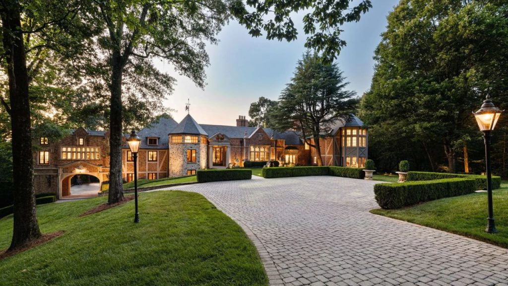 Elegant estate in Atlanta, GA, featuring a grand brick and stone exterior, a spacious driveway, and a beautifully landscaped entrance.