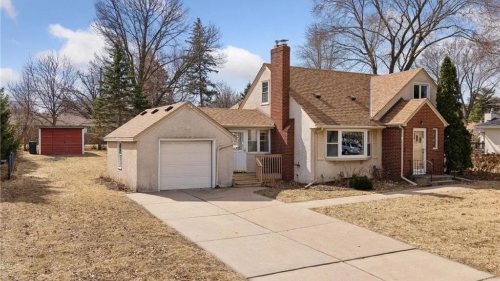 Cozy mid-century suburban home with detached garage and bay window.