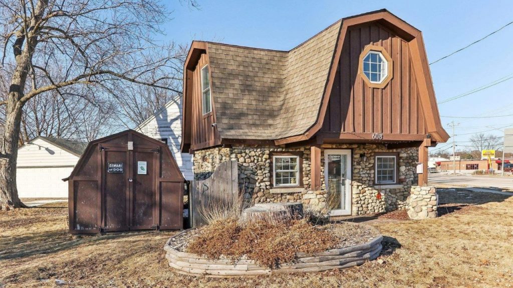 Cozy stone cottage with wavy roof and quirky fairytale charm.