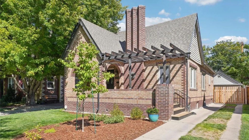 Front yard with brick home, pergola, and neat landscaping in Denver.