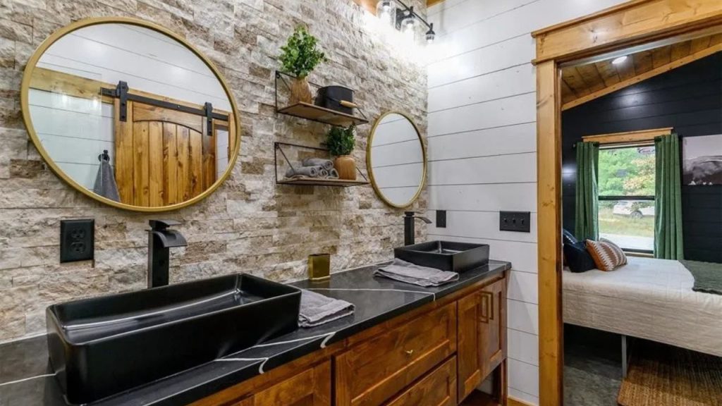 Double sink bathroom with wood cabinets and round mirrors