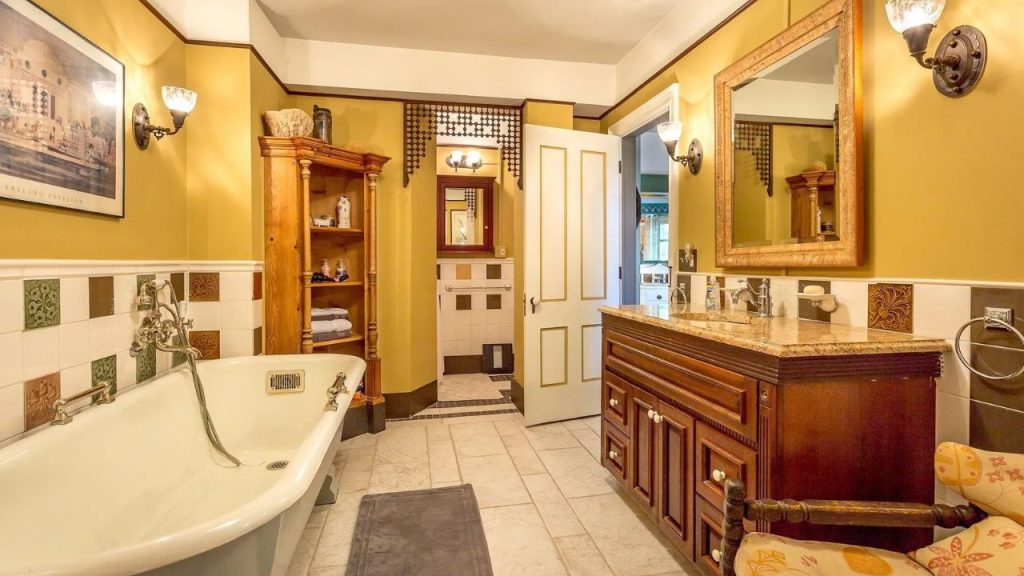 Cozy bathroom with vintage tub, wood vanity, and warm-toned walls.