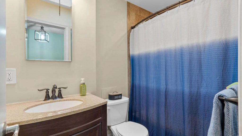 Cozy bathroom with blue ombre shower curtain and dark wood vanity.