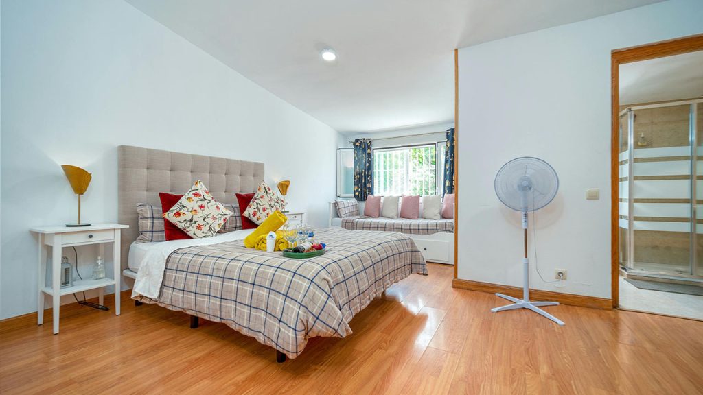 A Cozy Bed with Pillows Near the White Wall
