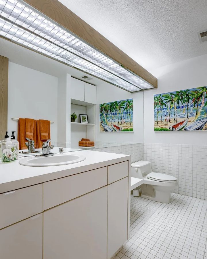 Bright bathroom with beach artwork and retro tile design.