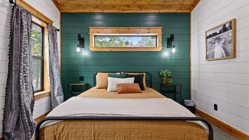 Bedroom with green accent wall and natural wood finishes