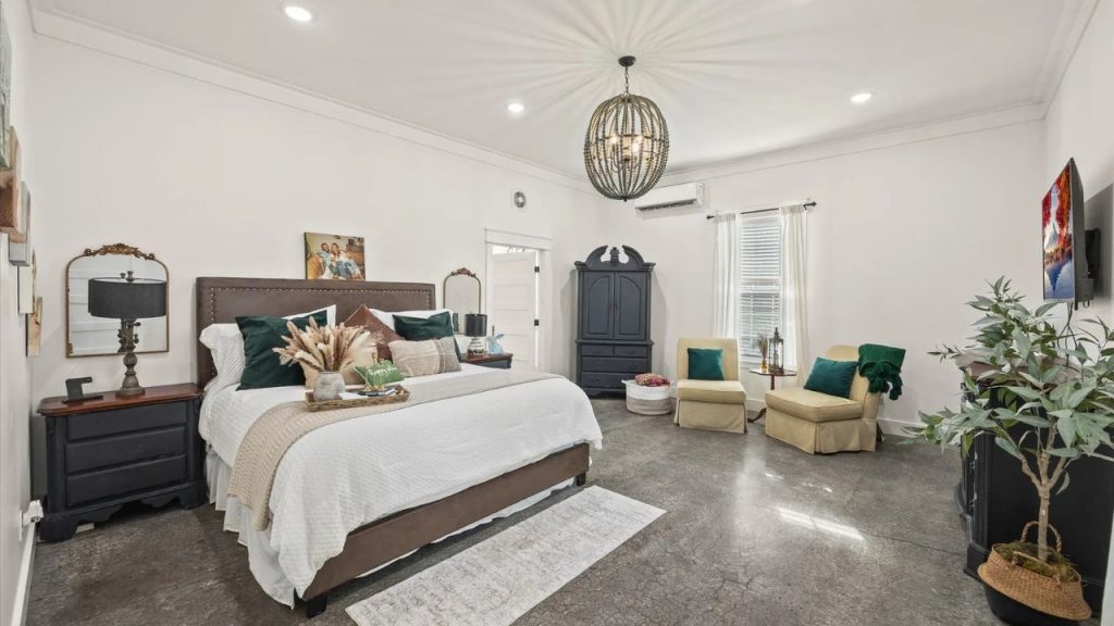 Spacious bedroom with a plush bed, cozy seating area, and elegant decor.