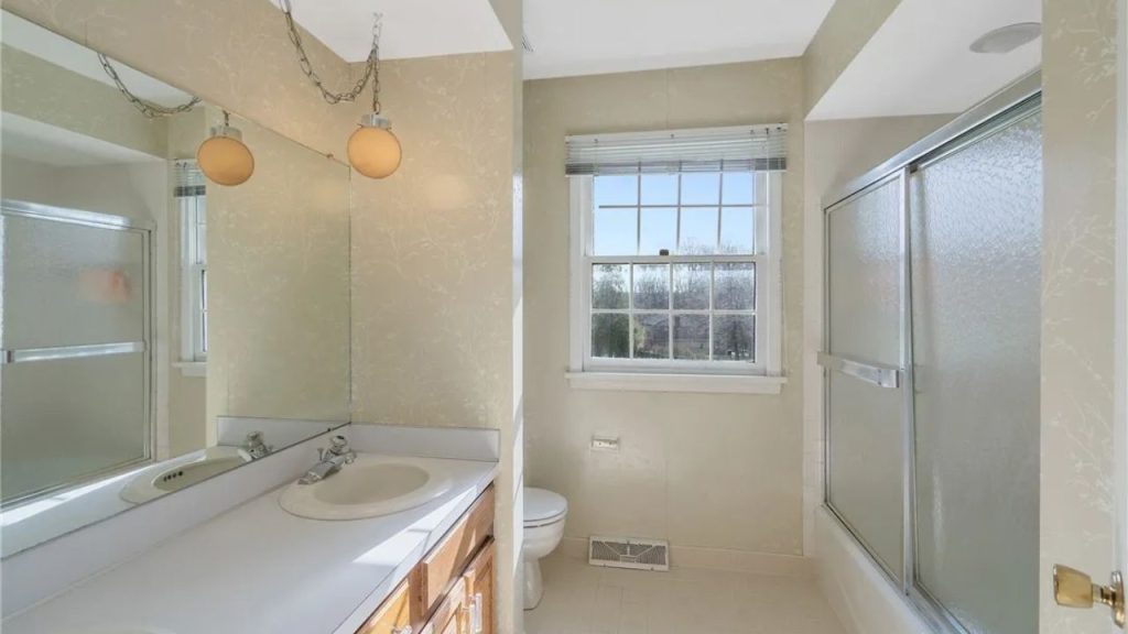 Beige bathroom with retro lighting and a frosted glass shower.