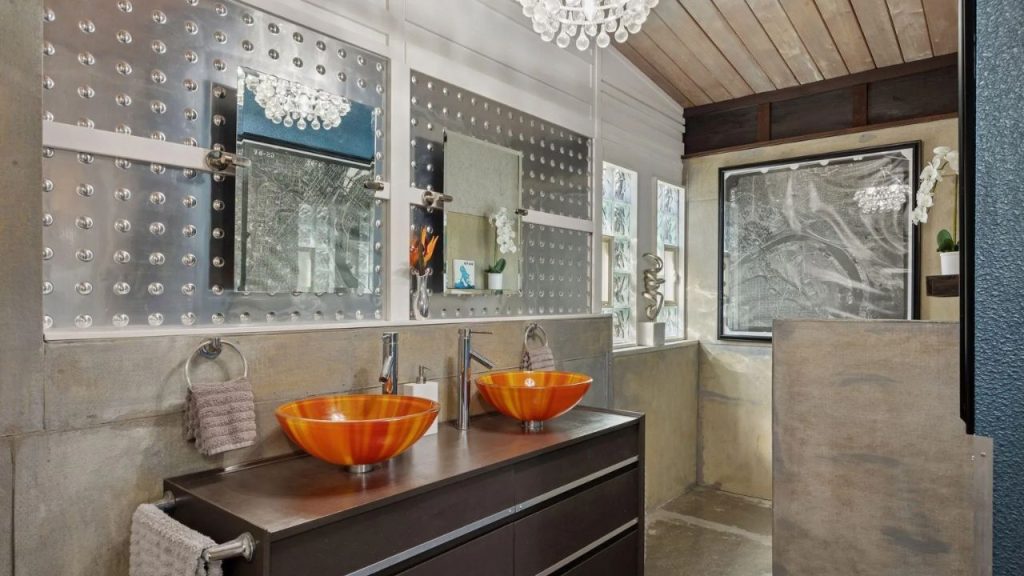 Modern bathroom with orange sinks, metal mirrors, and wood ceiling.