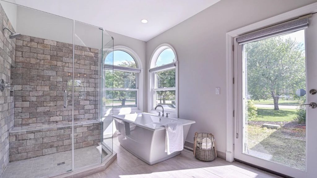 Spacious bathroom with a freestanding tub, glass shower, and outdoor access.