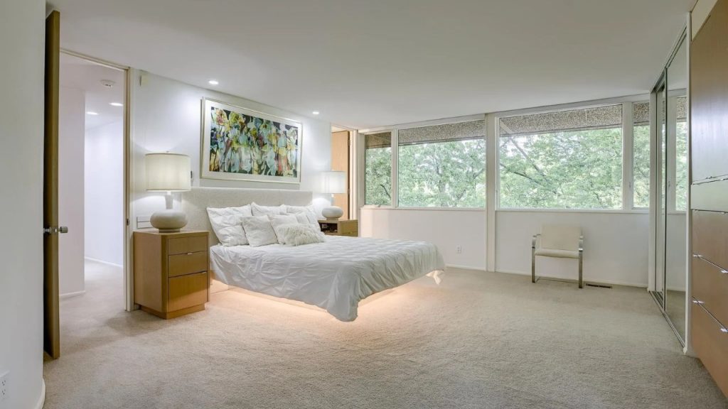 Peaceful bedroom with large windows and soft neutral tones.