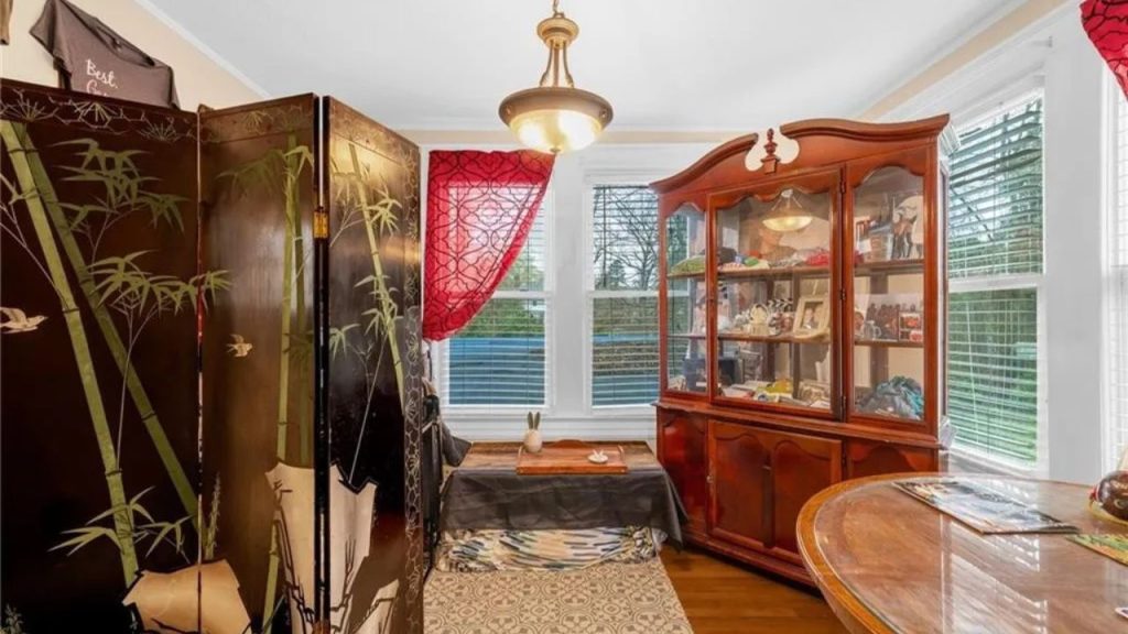 Cozy corner with floor seating, bamboo screen, and sunlit display cabinet.